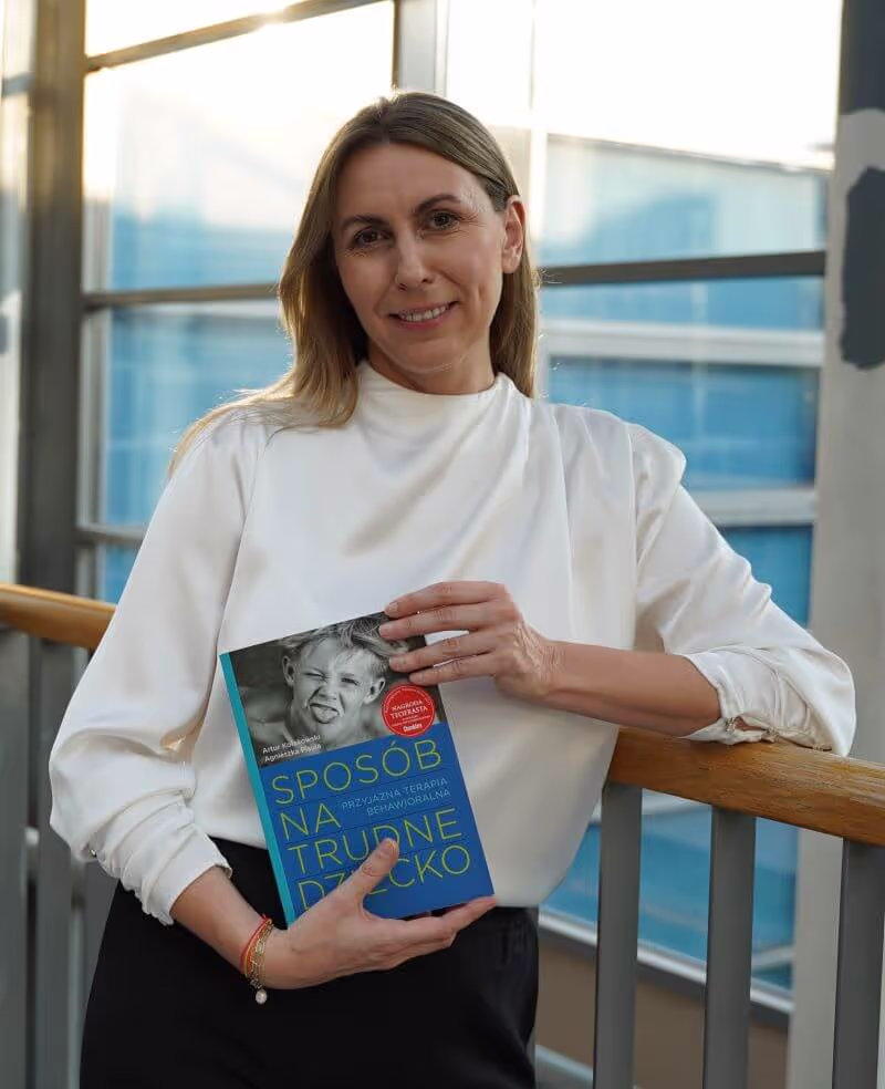Monika Molka Trener TUS trzymając książkę do TUS